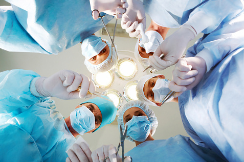 surgeons looking down while operating